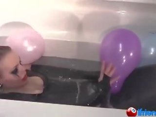 Κόμμι ντυμένοι κορίτσι με μπαλόνια σε ένα μπανιέρα