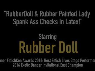 Rubberdoll & Rubber Painted lassie Spank Ass Checks in.